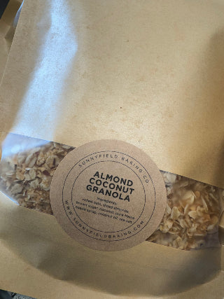Almond Coconut Granola package with a label on a light brown background